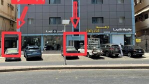 A modern building with a blue facade, multiple windows, and a sign in Arabic. - welcome apartment (Jeddah)