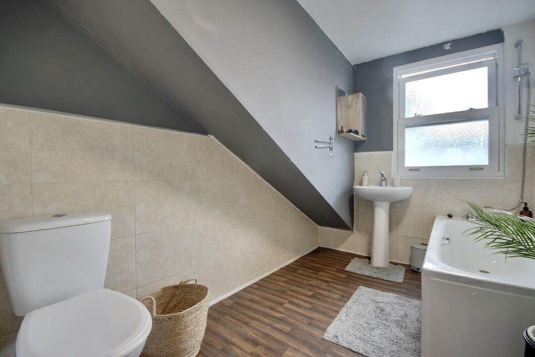 A bathroom with a toilet, sink, and bathtub.