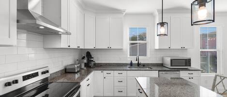 Een koffiezetapparaat/waterkoker, kookgerei, borden en bestek