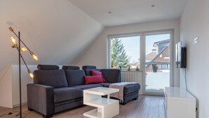 A modern living room with a grey sofa, white coffee table, and a floor lamp. - "Modern 2-room apartment in Troisdorf, centrally located - perfect retreat!" (Troisdorf)