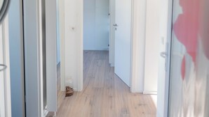 A hallway with wooden flooring, white walls, and doors leading to other rooms. - "Modern 2-room apartment in Troisdorf, centrally located - perfect retreat!" (Troisdorf)