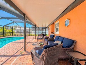 Eine Außenpatio mit Pool, Korbmöbeln und einem überdachten Bereich mit Blick auf die Umgebung.