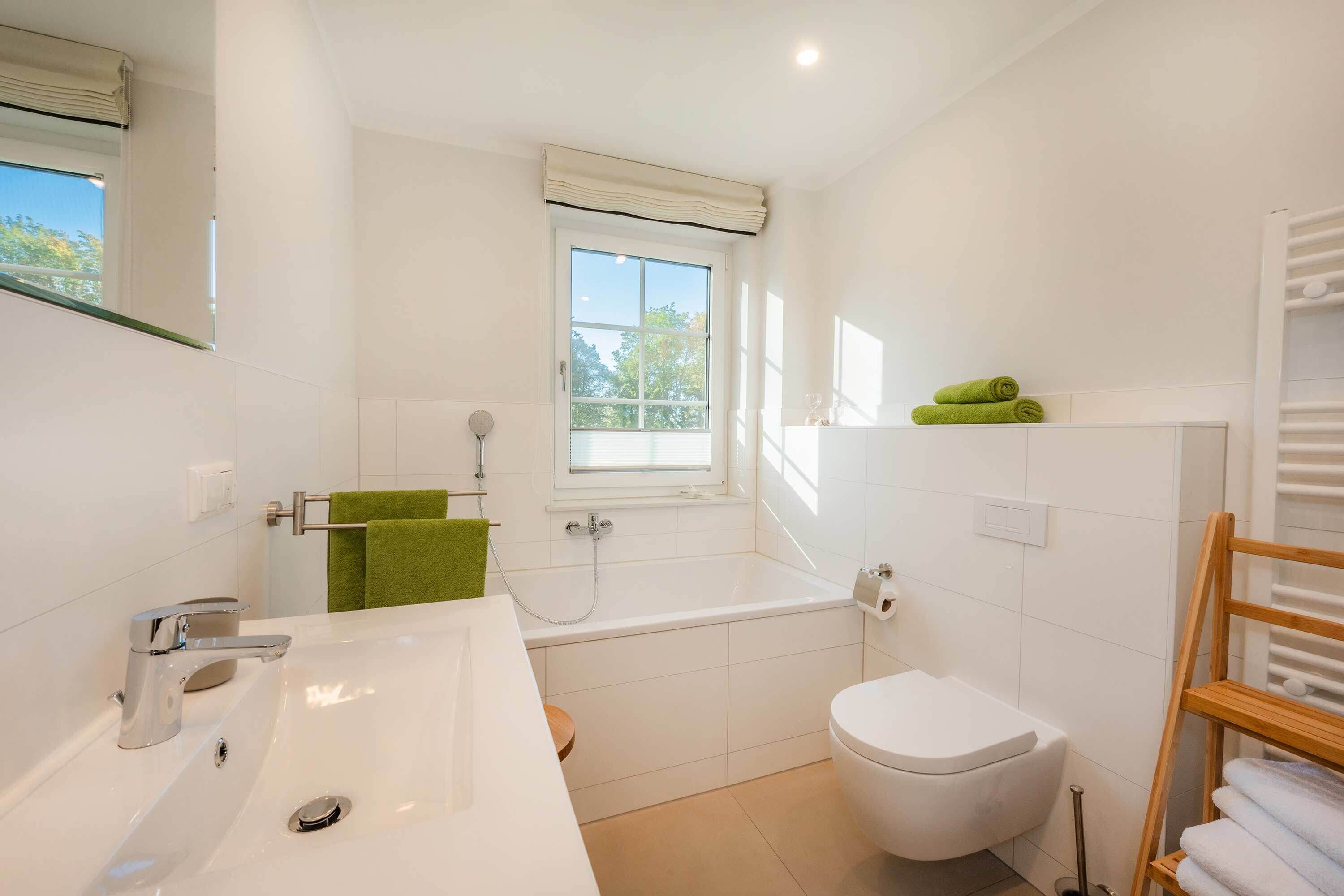 Ein modernes Badezimmer mit einer Badewanne, Toilette und Waschbecken.