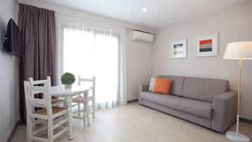 Apartamento, 1 habitación, balcón | Zona de estar | Televisión de pantalla plana de 32 pulgadas con canales por cable