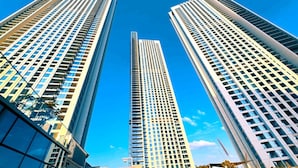 Three high-rise buildings with a clear blue sky in the background.
