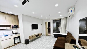 A modern apartment with a kitchen, living area, and a balcony.