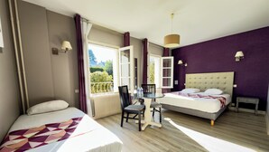 A hotel room with two beds, a dining table, chairs, a small table with a lamp, and a view of the outdoors. - Logis hôtel des voyageurs (Tarnac)