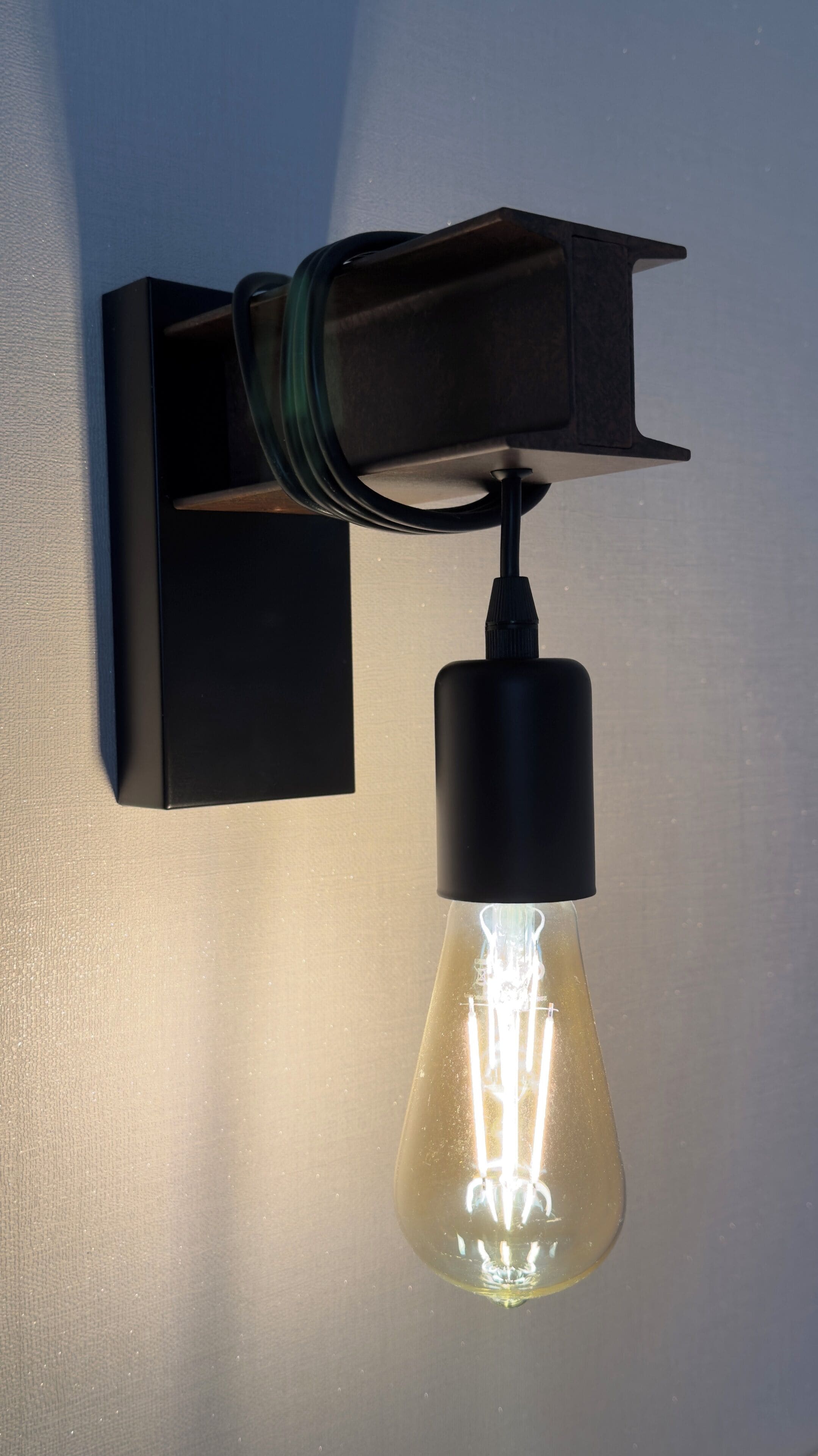 Eine Wandleuchte mit einer Glühbirne aus Klarglas.