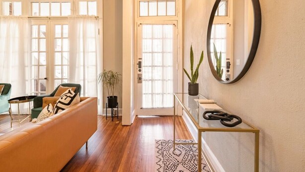 A living room with a sofa, a coffee table, and a potted plant.