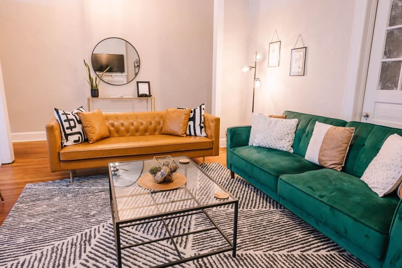 Un salon avec un canapé, une table basse et un divan vert.