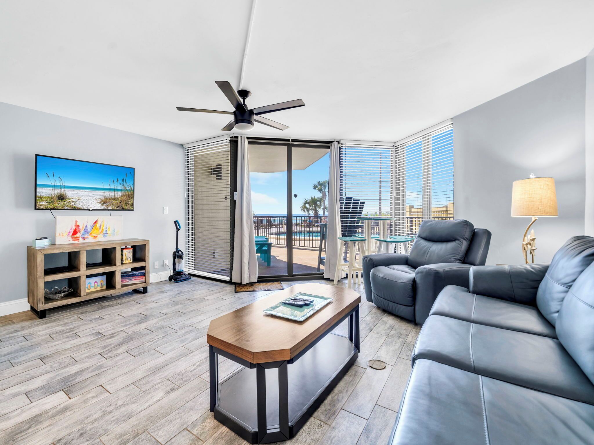 A modern living room with a sofa, coffee table, and a TV mounted on the wall.
