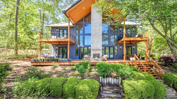 Een modern huis met een groot terras, een open haard en een stenen schoorsteen.