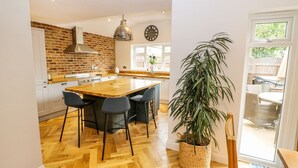Una cocina amplia con una isla grande, electrodomésticos modernos y una pared decorativa de ladrillo.