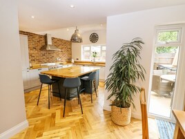 Una cocina amplia con una isla grande, electrodomésticos modernos y una pared decorativa de ladrillo.