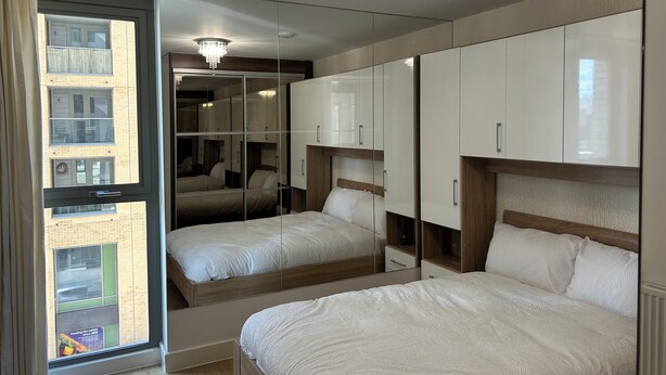 A bedroom with two beds, a large mirror, and a chandelier. - 1-Bed Apt, Sleeps 4, Near Attractions & Transport (Lewisham)