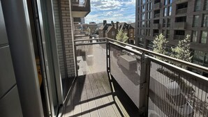 A balcony with a metal railing overlooking a cityscape with multiple buildings. - 1-Bed Apt, Sleeps 4, Near Attractions & Transport (Lewisham)