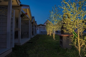 A residential area with houses, a grassy yard, and trees.