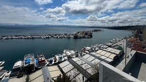A marina with boats docked, a clear sky, and distant mountains. - The Port Rooms (Sinop)