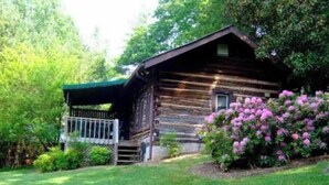 Eine rustikale Holzhütte mit Veranda und kleinem Fenster.
