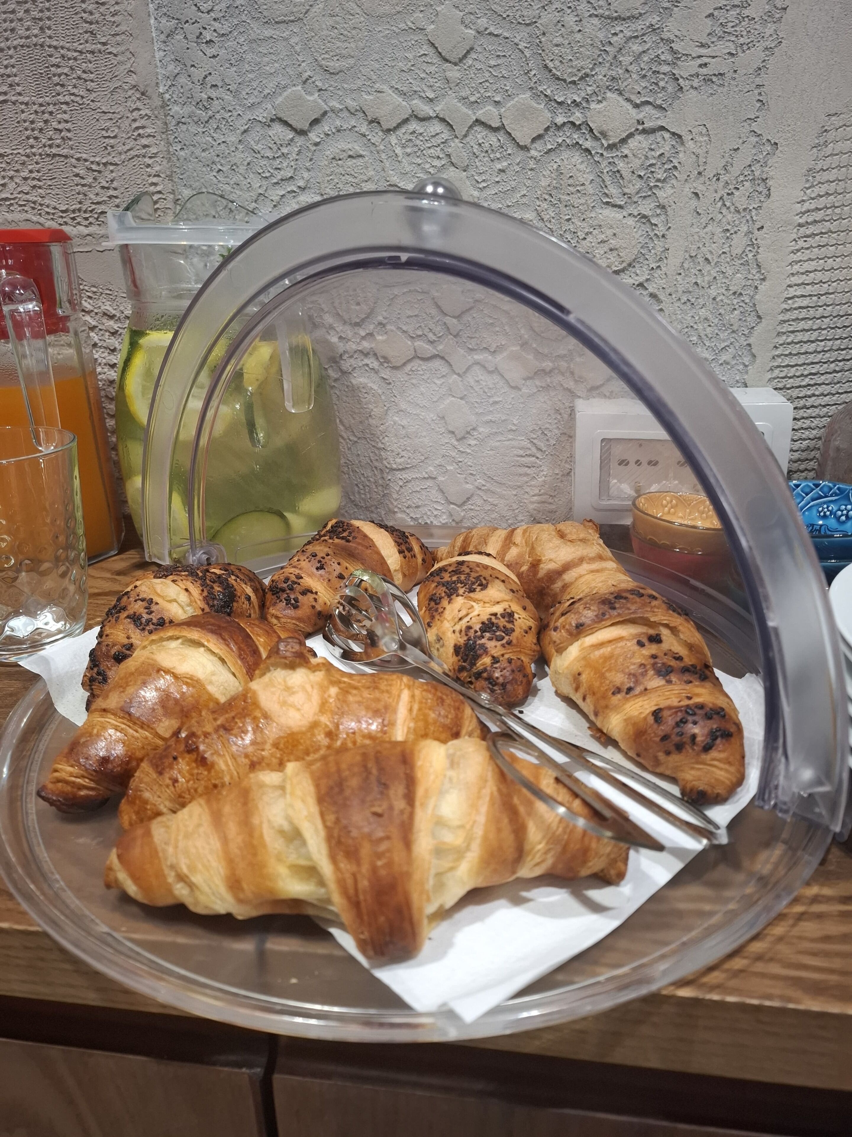 Ein Frühstücksbuffet mit Croissants und Fruchtsaft.