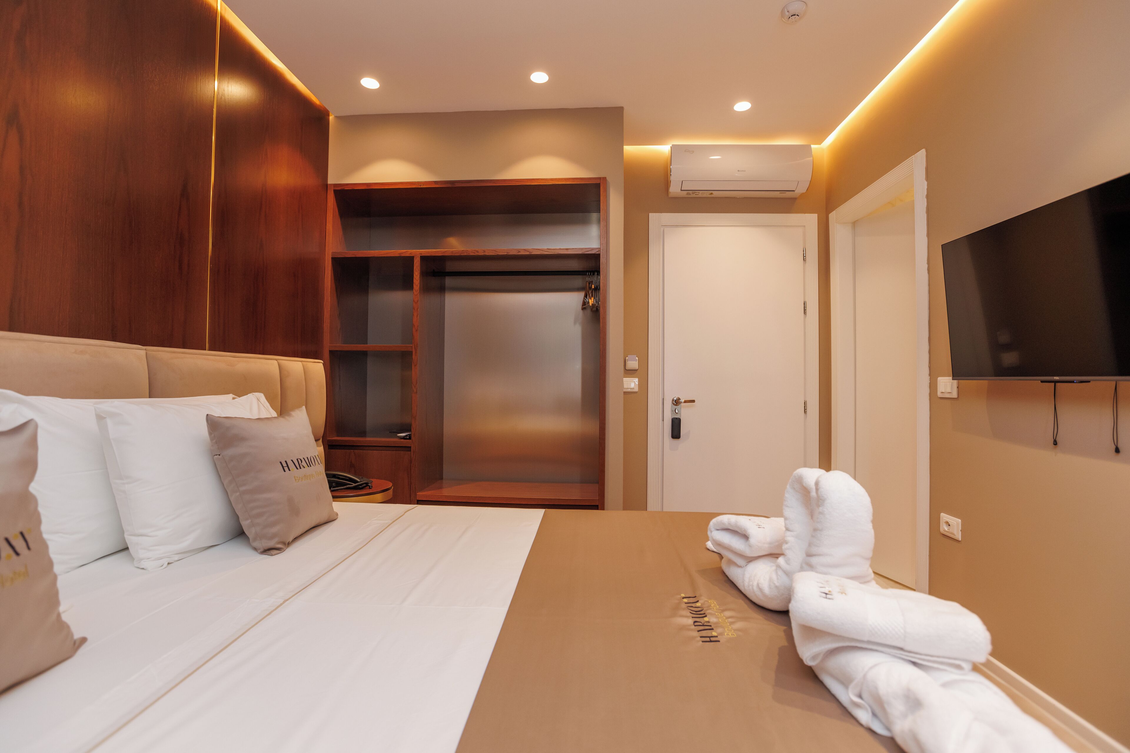 A hotel room with a bed, a wardrobe, a TV, and a bathroom.