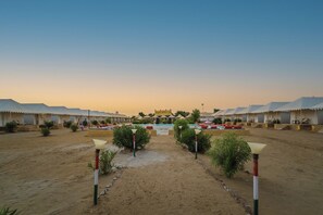 A desert resort with multiple tents and a central pool area.