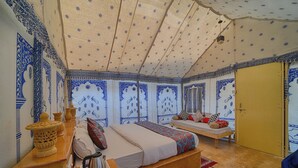 Ein Zimmer mit einem Bett, einem Tisch mit Wasserkocher und einer Wand mit Muster.