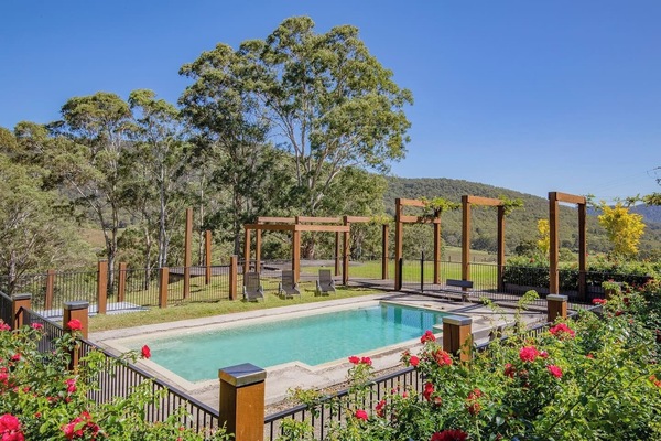 Swim among the roses—this sparkling pool is bordered by fragrant blooms and lush hedges, creating a private oasis under the Hunter Valley sun.