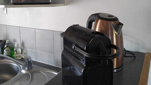 Keittiössä on kahvinkeitin, leivänpaahdin ja vedenkeitin työtasolla.