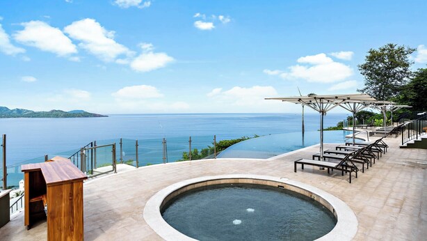 A pool area with a view of the sea, lounge chairs, and a wooden structure. - Luxury Condo with Panoramic Ocean Views, Sparkling Infinity Pool, and Modern Open-Concept Design (Cabo Velas)