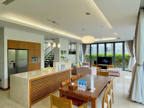Enjoy a spacious living area with a large flat-screen TV, dining area, and balcony with city views.