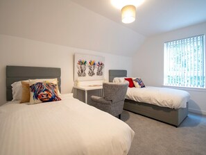 A hotel room with two beds, a desk, and a chair. There is a window with blinds and a ceiling light. - Beautiful Glasgow South Home - Pass the Keys (Glasgow)