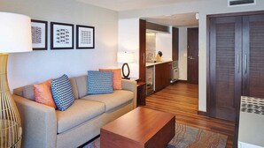 A modern hotel room with a sofa, coffee table, and a kitchenette area. - HGVC Hokulani Waikiki Luxury, 1 BR Suites, Rooftop Pool/Spa, Close to Ft Derussy (Honolulu)