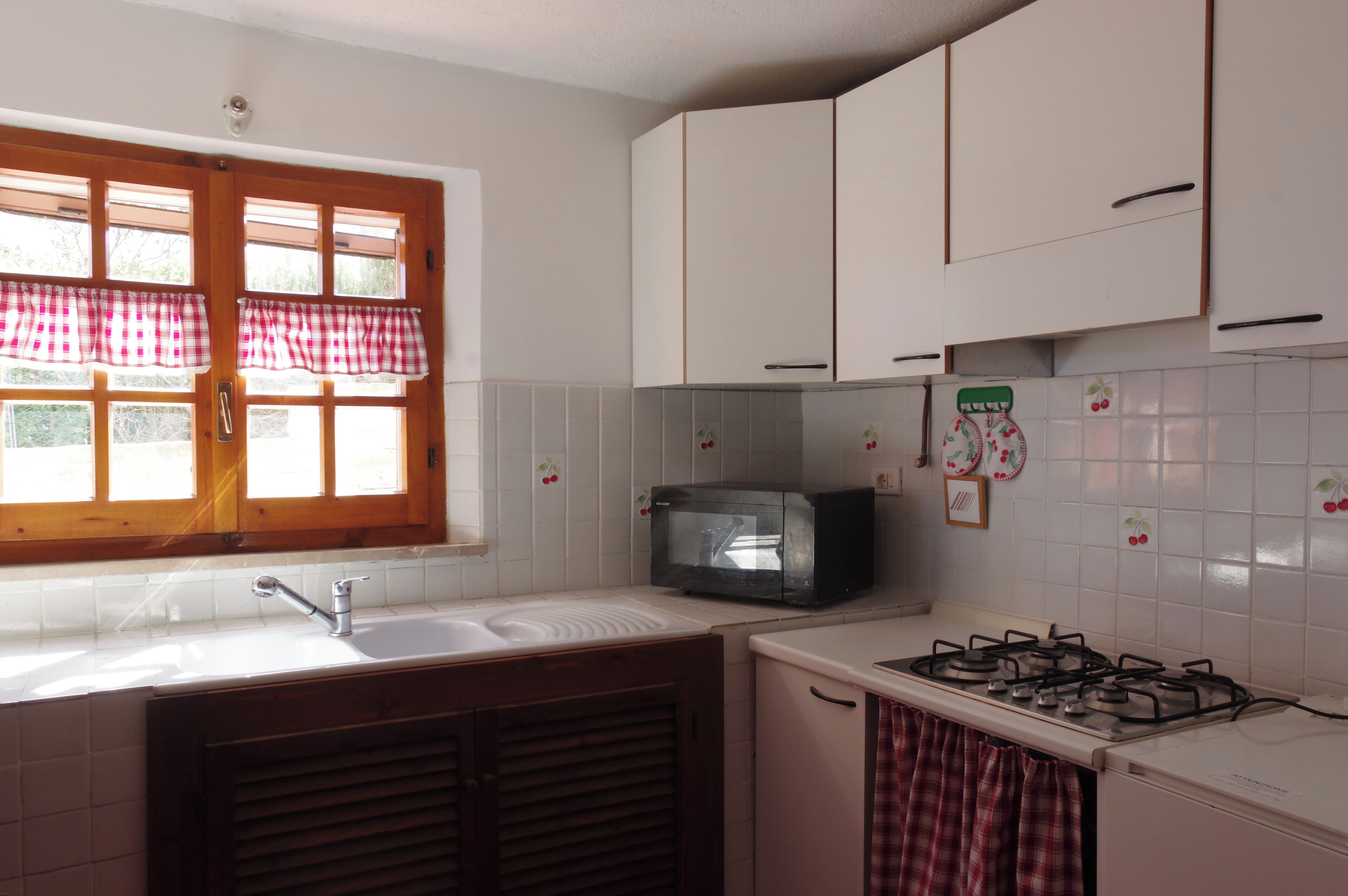 A kitchen with a sink, a microwave, and a gas stove.