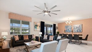 A modern living room with a sofa, chairs, a coffee table, and a dining area with a table and chairs. - Last Minute Disney! Private Pool, Hot Tub, Game Room & Themed Bedrooms. Book Now! #38250 (Orlando)