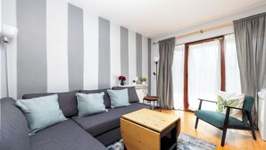 A modern living room with a grey sectional sofa, a wooden coffee table, a green armchair, and a small side table with decorative items. - Chic 2Bed W/Canal Views, 15 Min to Kilmainham Gaol (Kilmainham)