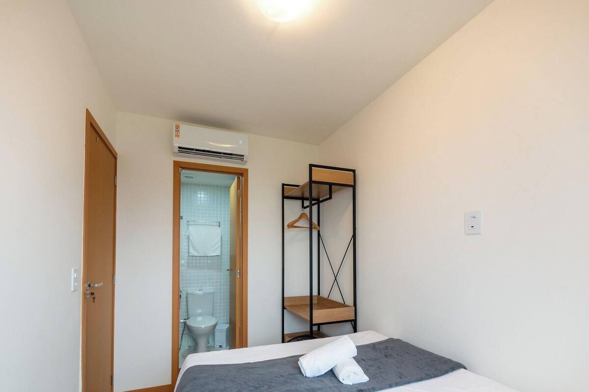 Et lille, rent rum med en seng, køjeseng, dør og aircondition.