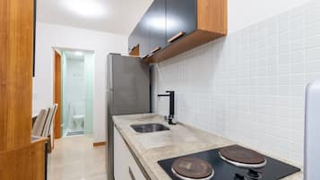 Uma cozinha moderna com frigorífico de aço inoxidável, uma pia dupla e fogão embutido.