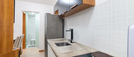 A modern kitchen with a stainless steel refrigerator, a double sink, and a built-in stove.