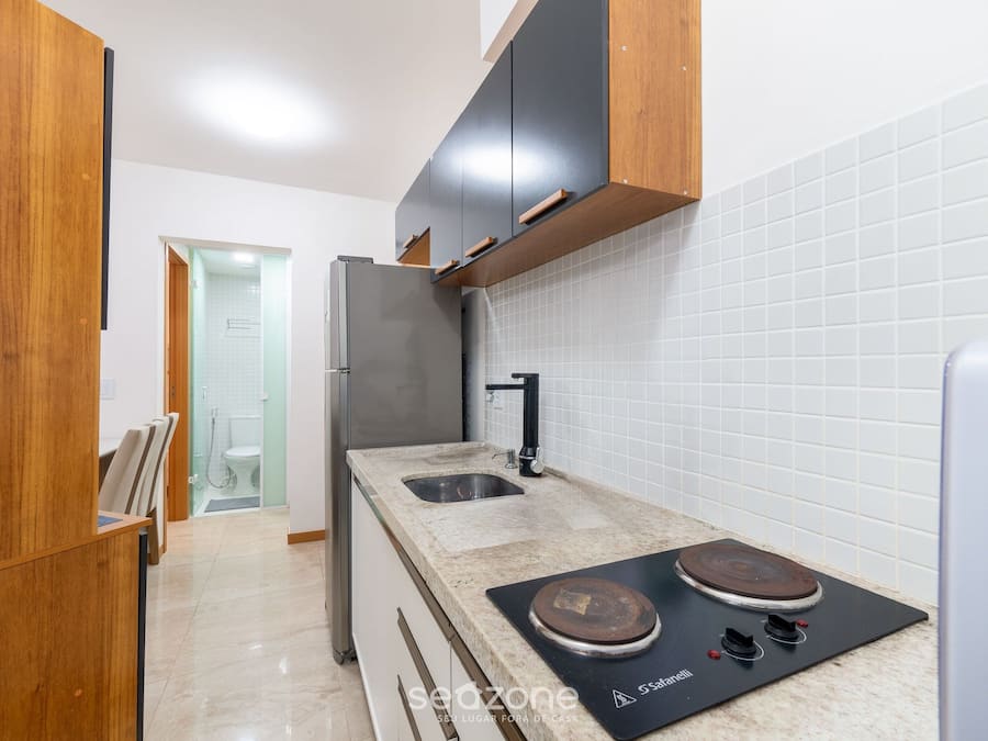 Una cocina moderna con un refrigerador de acero inoxidable, un lavamanos doble y una estufa integrada.