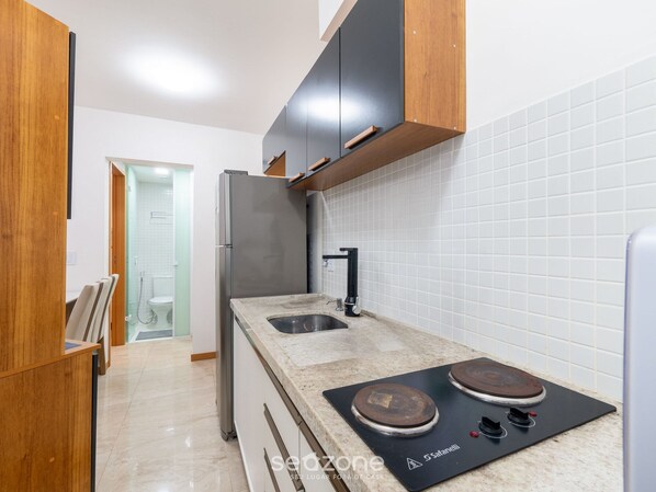 A modern kitchen with a stainless steel refrigerator, a double sink, and a built-in stove.