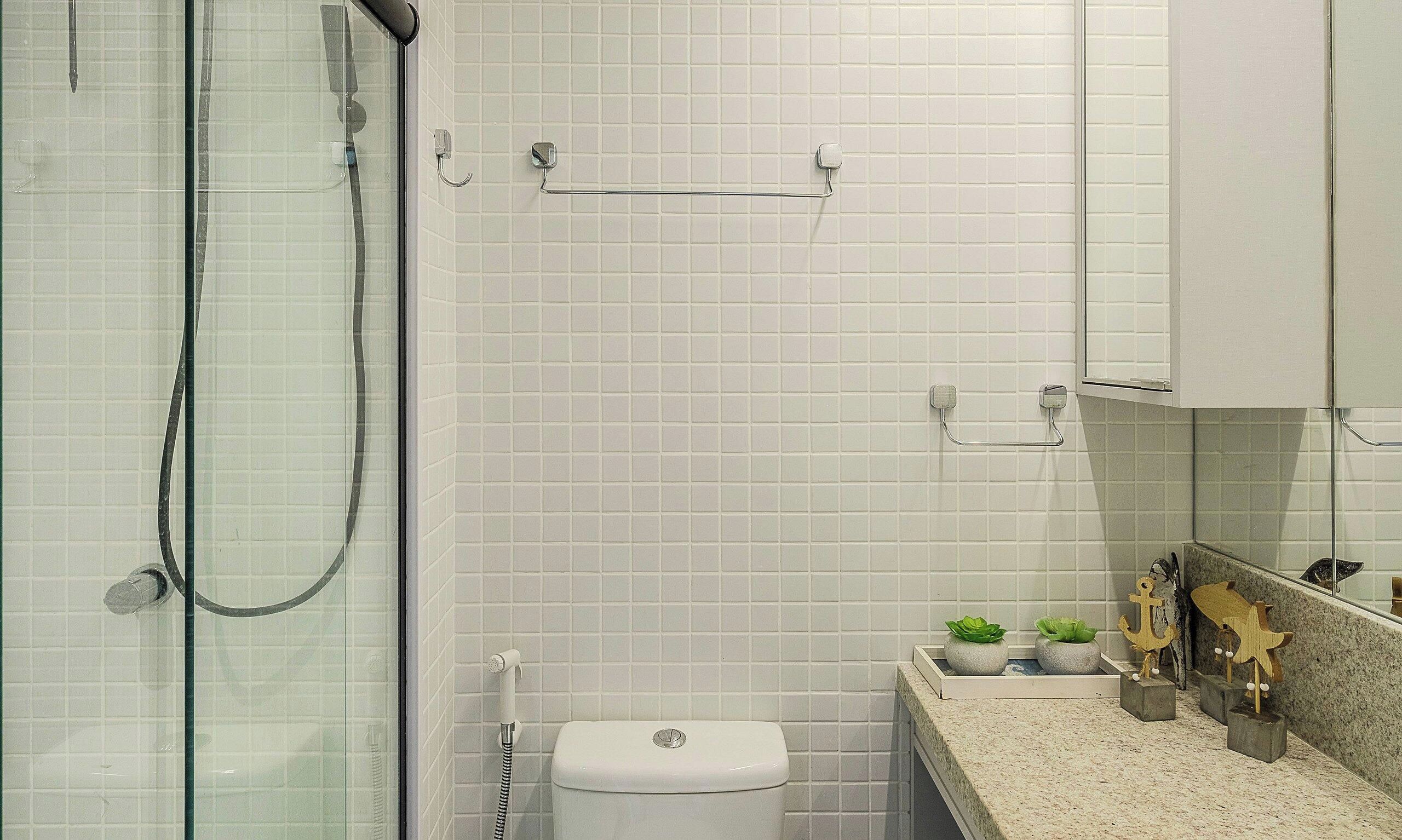 Ein Badezimmer mit Duschkabine, Toilette, Waschbecken mit Ablagefläche und Spiegel.