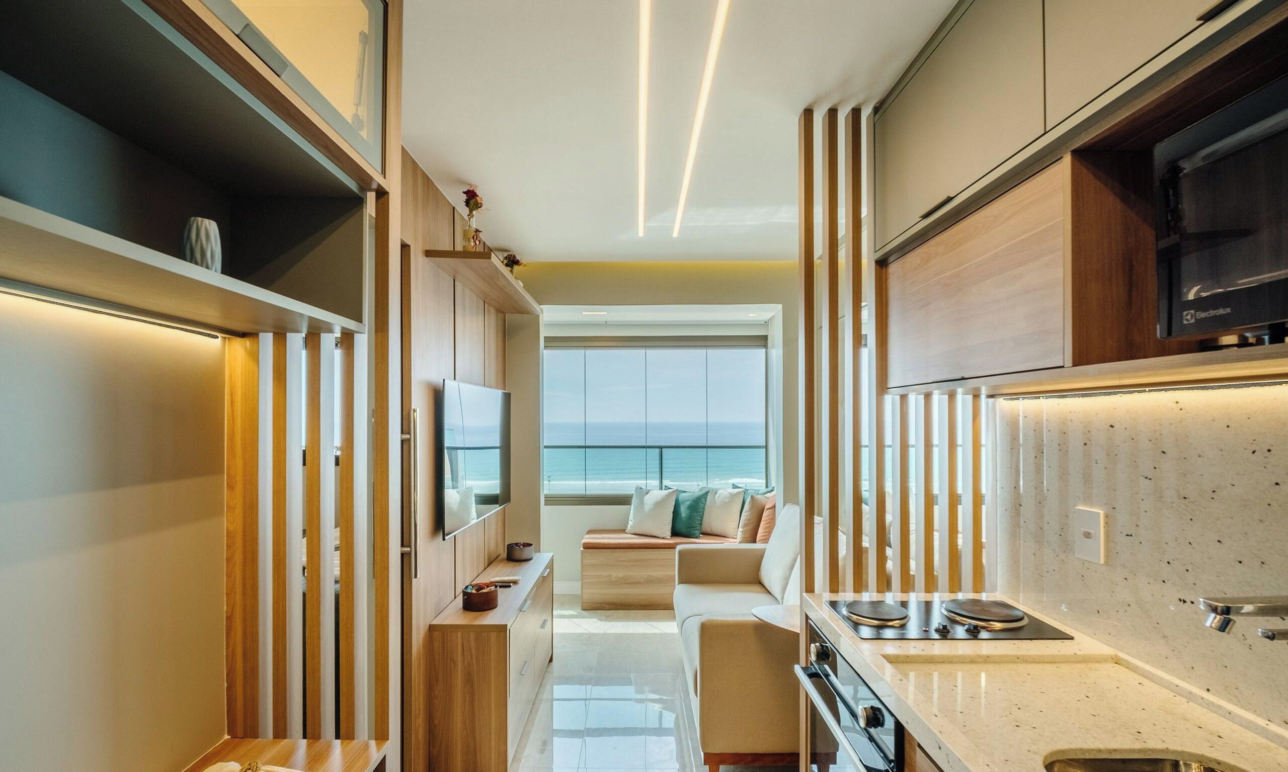 Cocina moderna con vistas al mar, zona de comedor con sofá y un pequeño rincón con vistas.