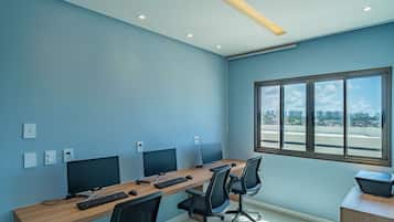 A conference room with a long table, two monitors, a keyboard, and chairs.