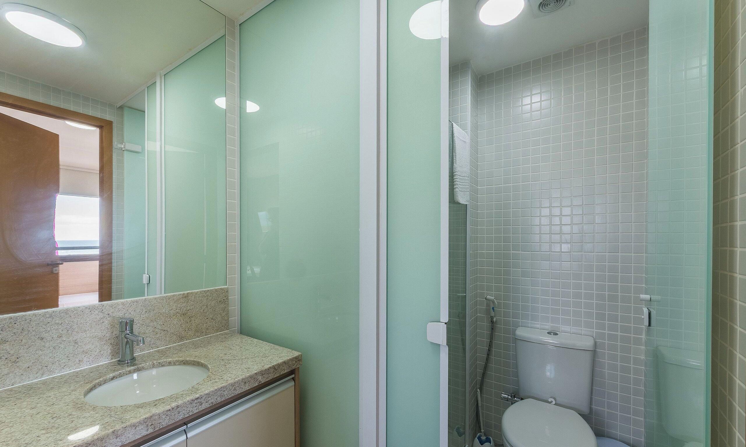 A bathroom with a sink, mirror, and shower.
