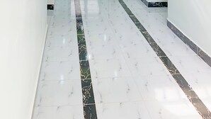 A modern hallway with a marble floor, recessed lighting, and a glass door at the end. - BUZIGA HOTEL (Kampala)