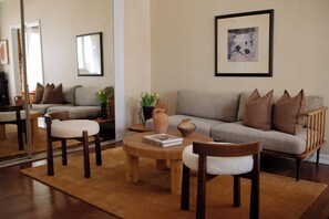 A living room with a sofa, two armchairs, a coffee table, and decorative items.