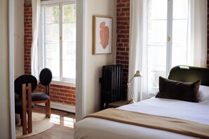 A hotel room with a bed, a chair, a radiator, and a window with curtains. - Studio in the heart of Hollywood (Los Angeles)