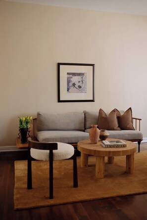 A living room with a sofa, a coffee table, and a framed picture on the wall. - Studio in the heart of Hollywood (Los Angeles)