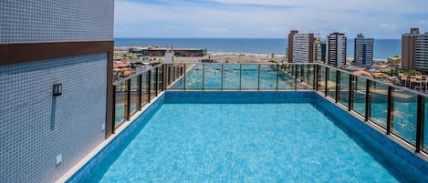 Piscina en la azotea con vistas despejadas al océano y al paisaje urbano.